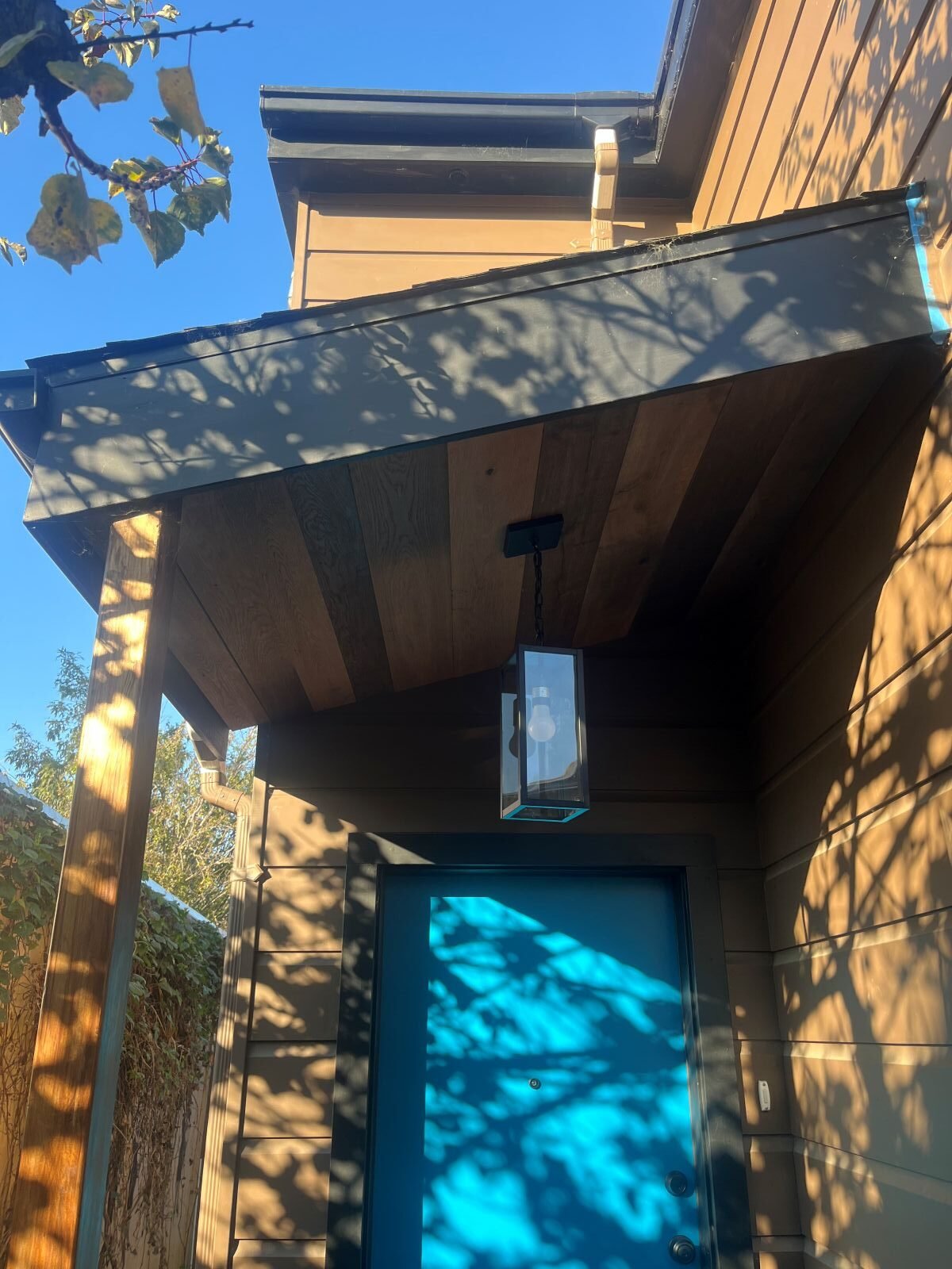 Front entry of finished 800 sq ft two-story ADU in Oakland featuring modern front door with exterior pendant lighting